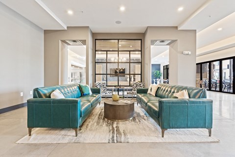 A living room with two green couches and a coffee table.