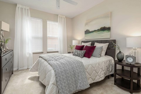A bedroom with a large bed and a ceiling fan.