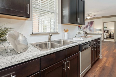 A modern kitchen with dark wood cabinets and a white sink.