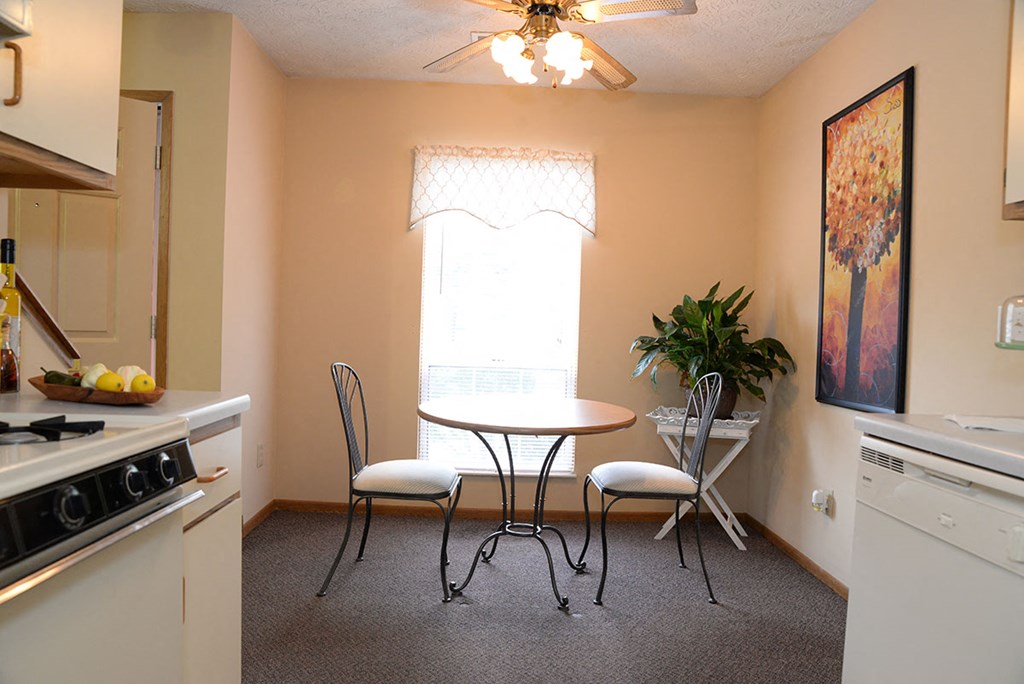 A kitchen with a table and chairs by the window.