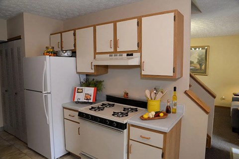A kitchen with a white refrigerator and a stove top oven.
