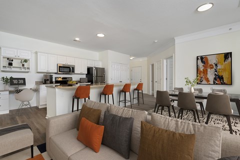A modern living room with a grey couch and a painting on the wall.