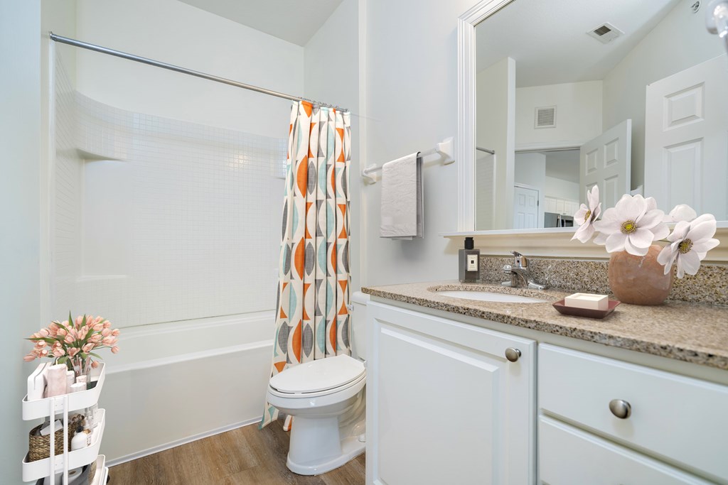 A white bathroom with a toilet, sink, and shower.at Arlington Park, Hilliard, OH