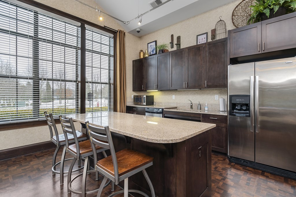 A kitchen with a table and chairs and a refrigerator.at Arlington Park, Hilliard, OH 43026