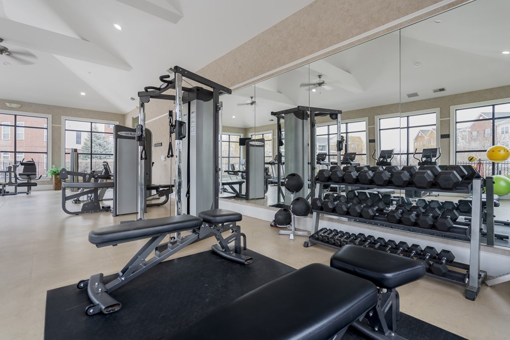 A gym with a variety of equipment including weights and a bench.at Arlington Park, Hilliard, OH