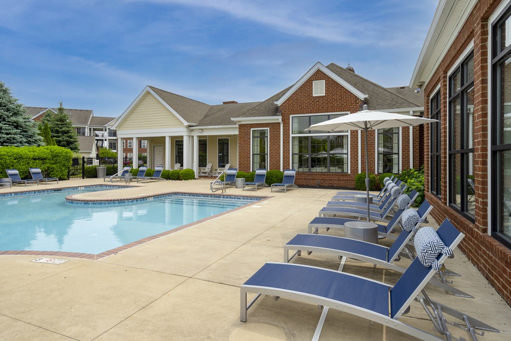 A pool with sun loungers and a house in the background.at Arlington Park, Hilliard Ohio