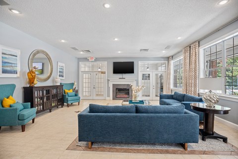 A living room with a blue couch and a fireplace.