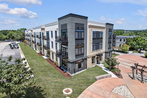 A modern apartment complex with a mix of beige and dark grey buildings.