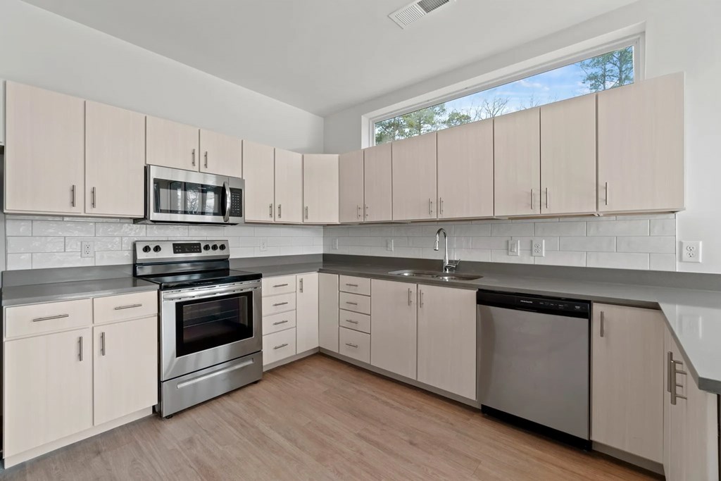 a kitchen with white cabinets and stainless steel appliancesat Metropolis Apartments, Virginia, 23060