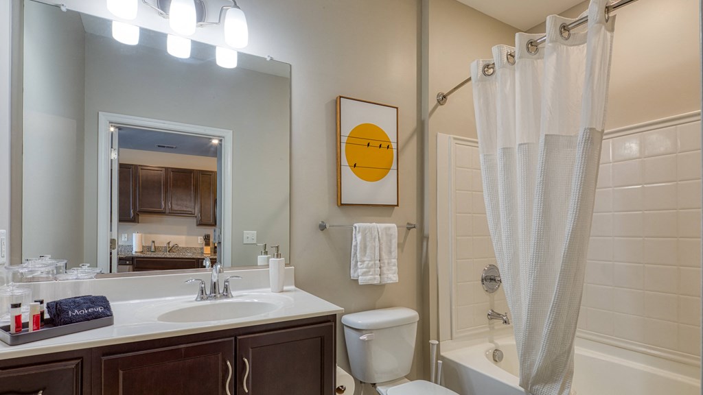 a bathroom with a sink toilet and shower and a mirror