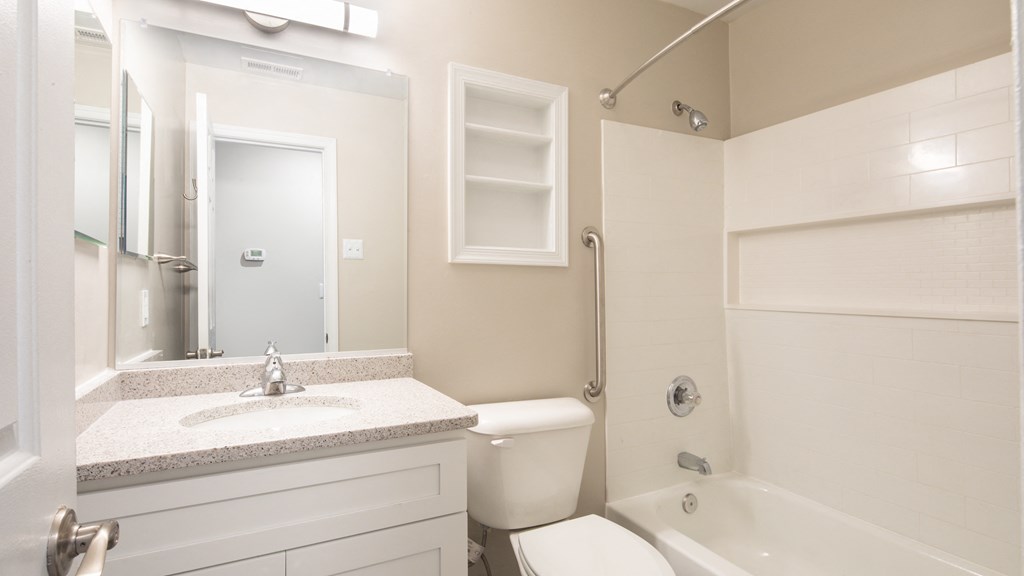 a bathroom with a toilet sink and shower and a mirror