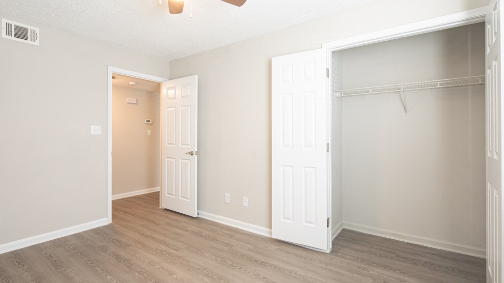 an empty room with two doors and a closet