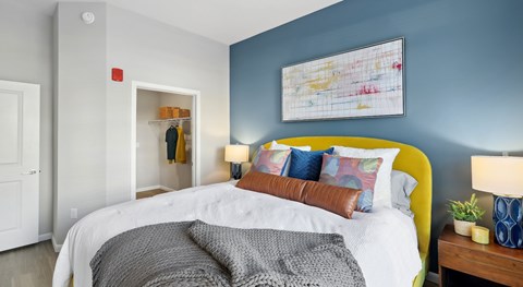 A bedroom with a white bed and a yellow headboard.