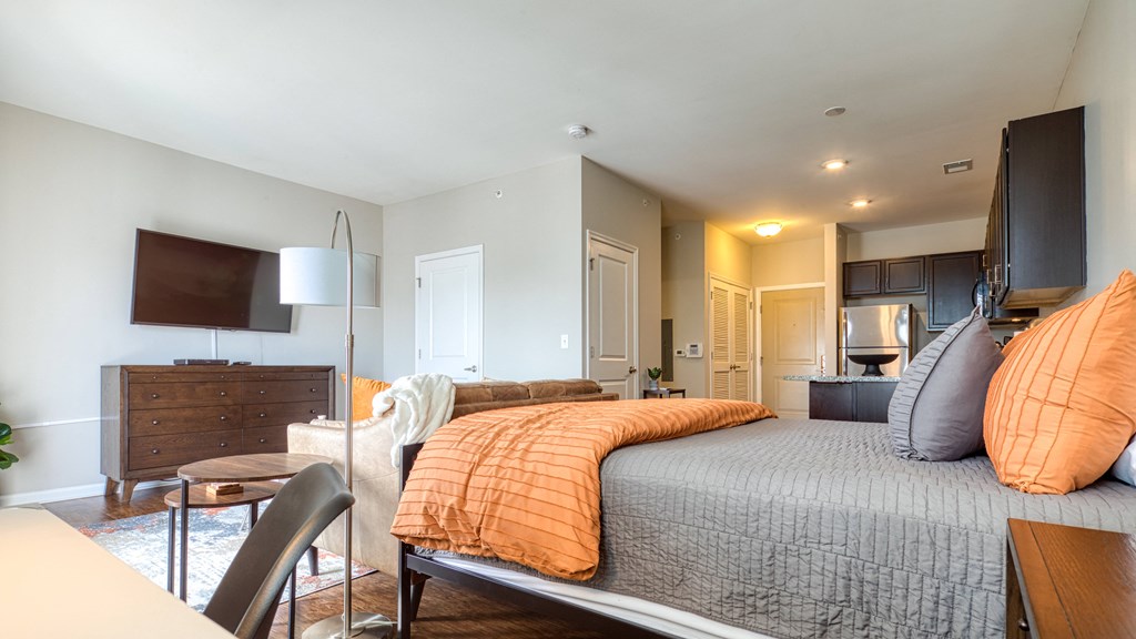 a bedroom with a bed and a living room with a tv