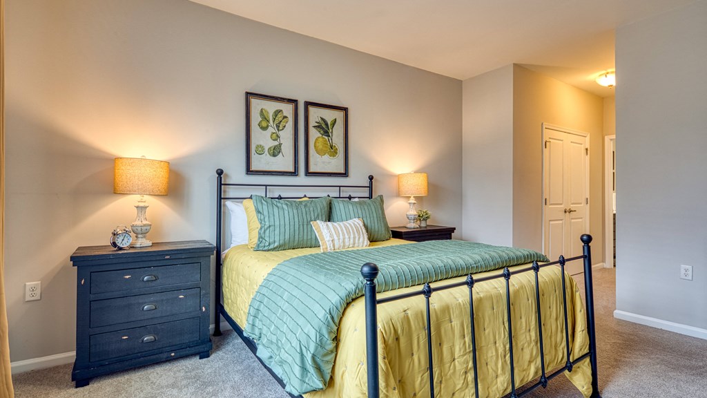 a bedroom with a bed and a dresser with two lamps