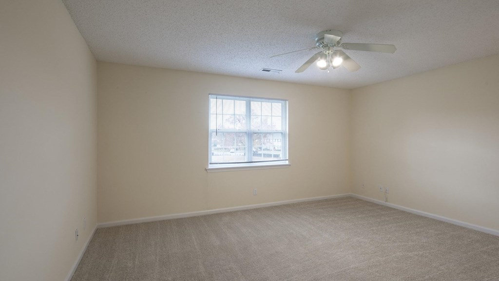 A room with a ceiling fan and a window.