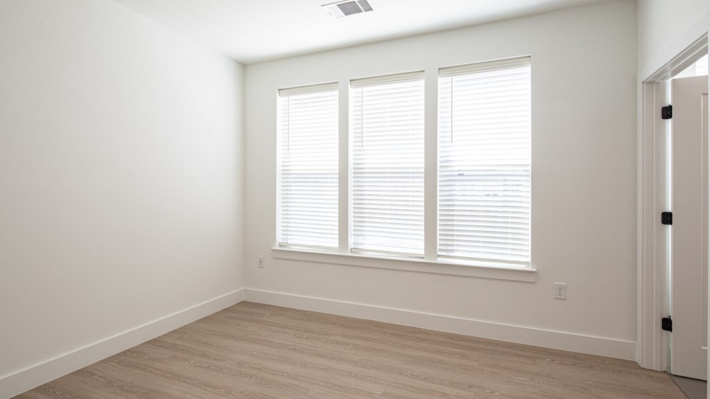 a bedroom with white walls and a wooden floor at Ainsworth, Richmond, VA