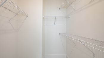 a walk in closet with white walls and white shelves at Ainsworth, Richmond, 23228