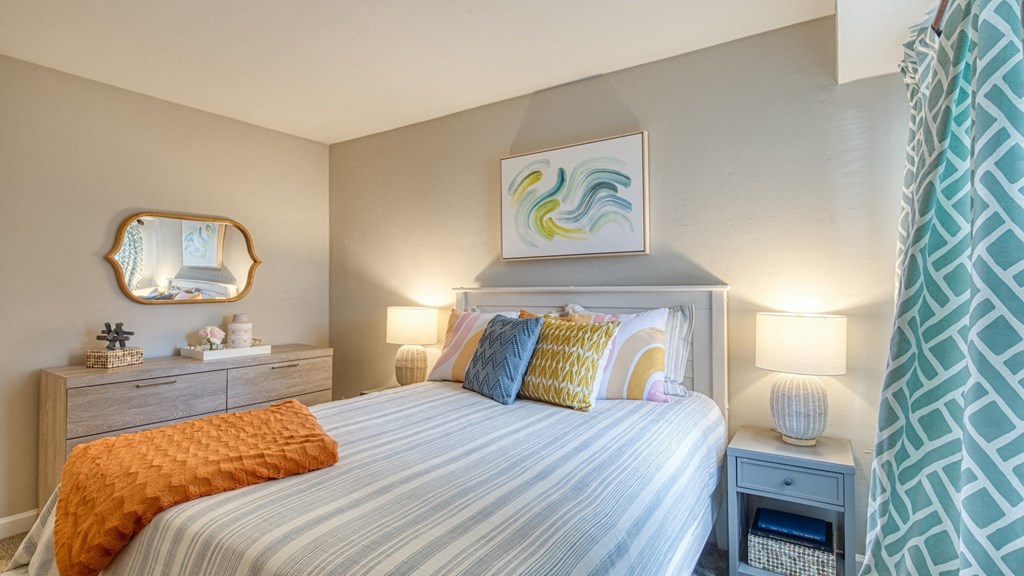 a bedroom with a large bed and two nightstands with lamps