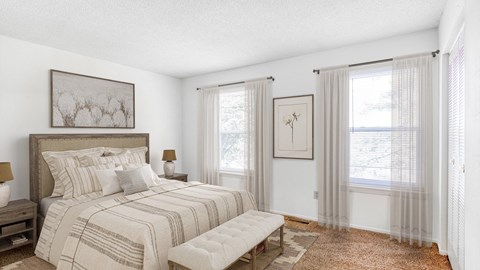 A bedroom with a large bed and a bench in front of it.