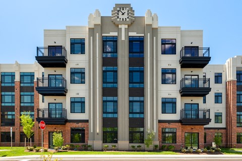 A large building with a clock on the front and balconies on the upper floors.