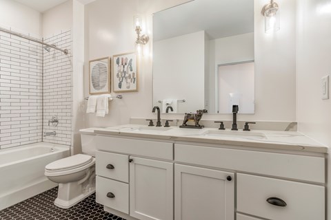 A white bathroom with a toilet, sink, and mirror.