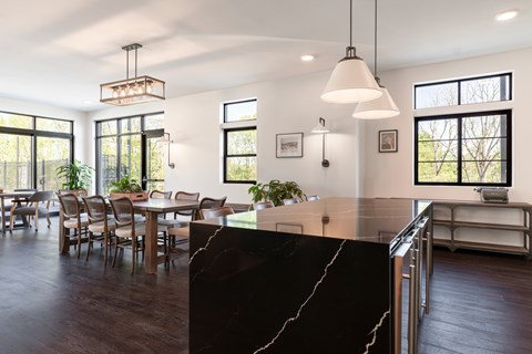 A modern kitchen with a black marble countertop and wooden floors.