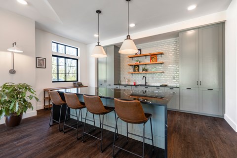 A kitchen with a bar area and chairs.