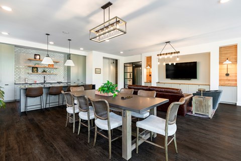 A modern dining room with a large table and chairs.