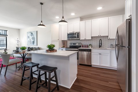 A kitchen with white cabinets and a wooden floor.