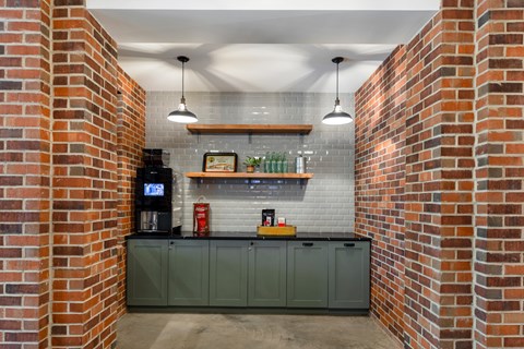 A brick wall with a green cabinet under it.