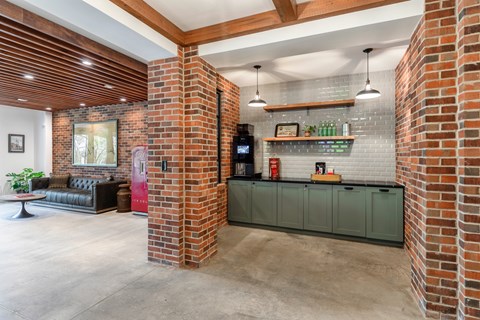 A kitchen area with a brick wall and a green cabinet.