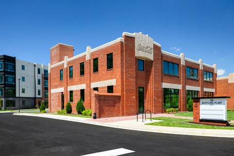A Coca-Cola sign is on the front of a brick building.