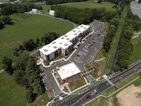 A large white building with a parking lot in front of it.