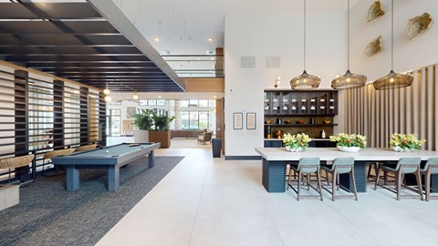 a communal area with a pool table and a dining table and chairs