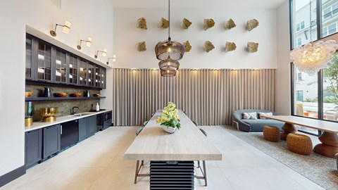 a dining room with a long wooden table and a kitchen