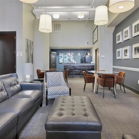 A modern living room with a grey sofa and a patterned chair.
