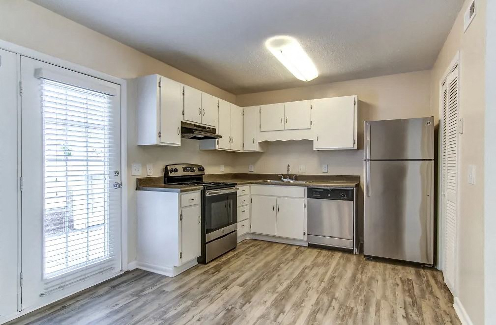 A kitchen with white cabinets and stainless steel appliances.