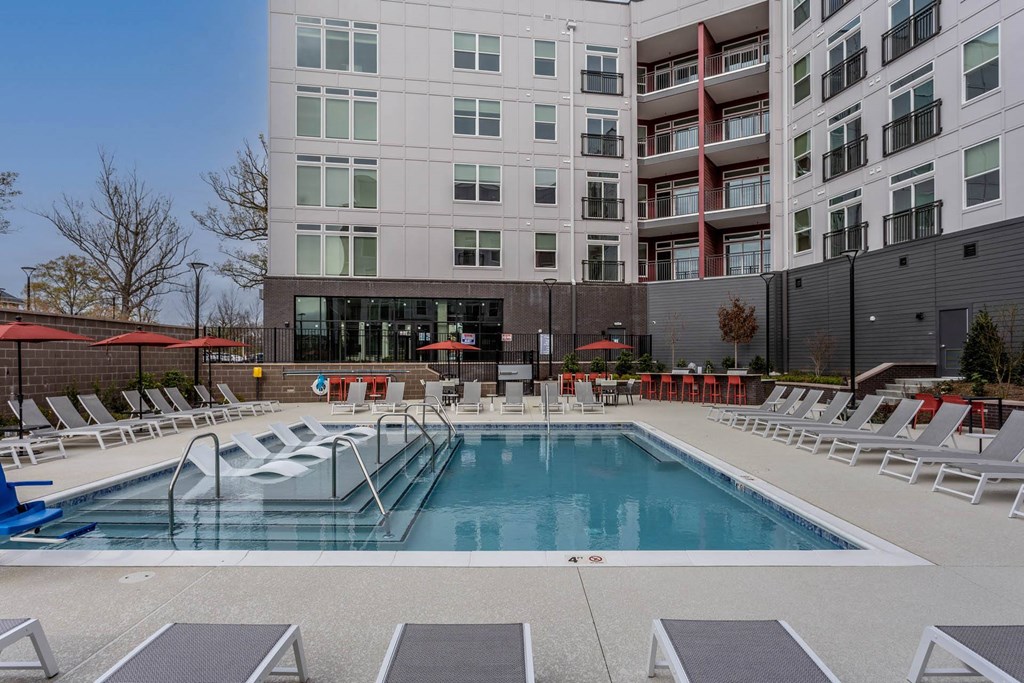 a swimming pool at a building with chairs around itat Centro at Pine Nash, Wilson, NC, 27893