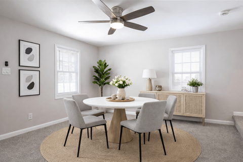 A dining room with a round table and chairs.