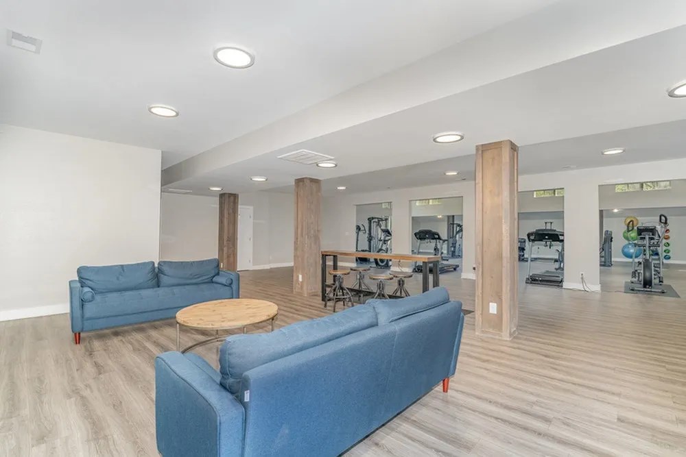 a living room with blue couches and a table at Village 1373, Greensboro, 27455