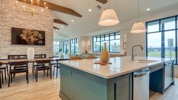 a kitchen with a large island and a dining room with a table and chairs at Allure at Edinburgh, Virginia, 23322