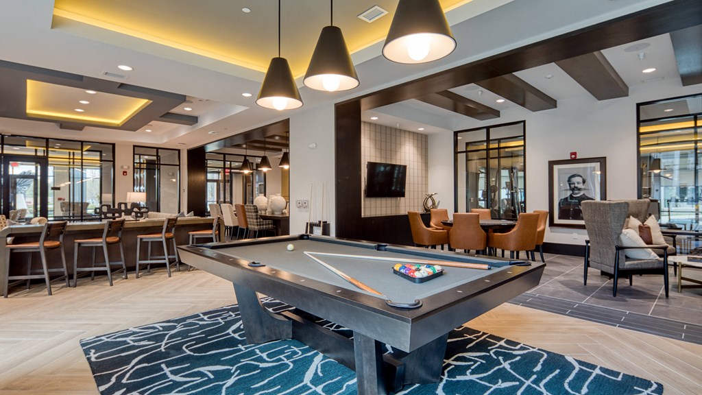 a billiards table in a clubhouse with tables and chairs at Aura Stonebridge, Richmond Virginia