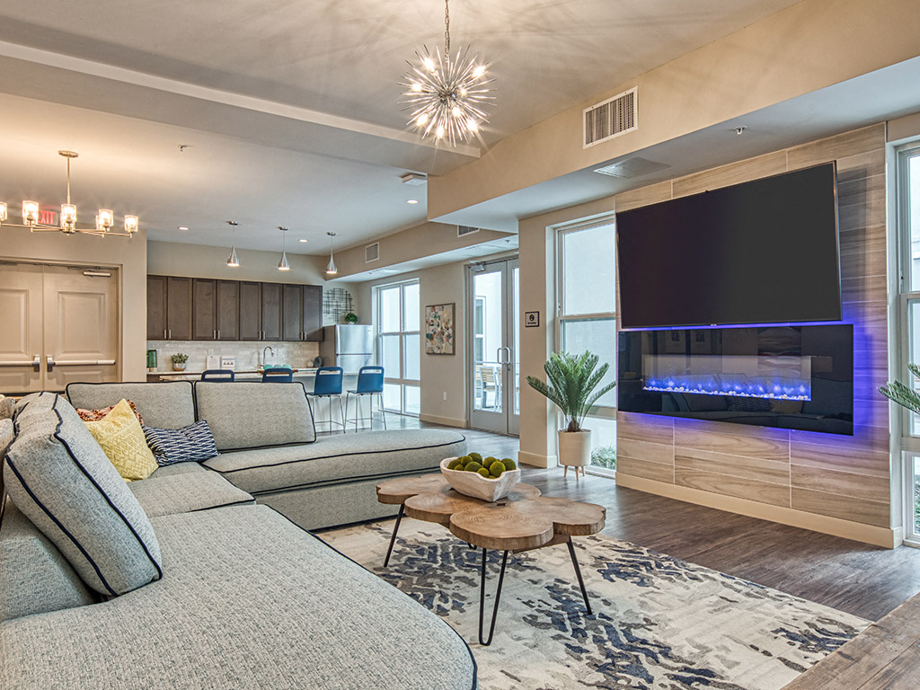 A modern living room with a grey sofa and a fireplace.