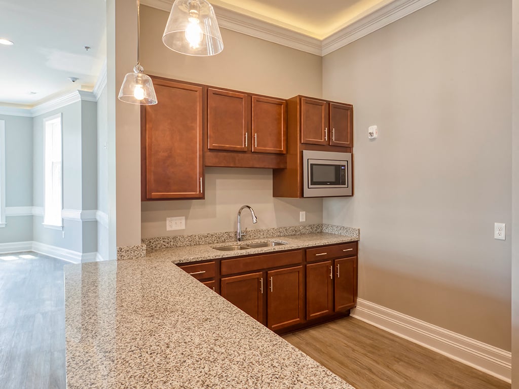 A kitchen with brown cabinets and granite countertops.