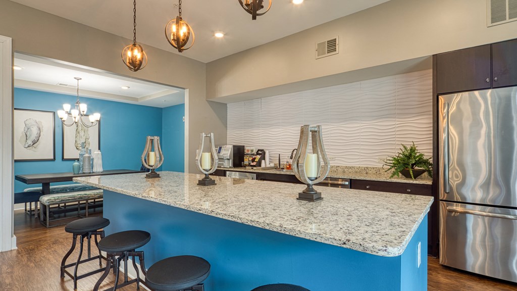 a kitchen with a large counter top and a stainless steel refrigerator