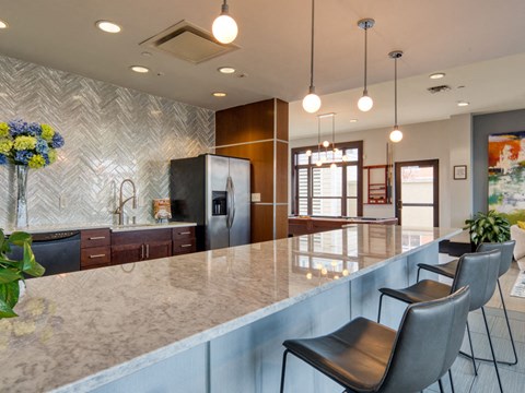 a kitchen with a long counter and chairs