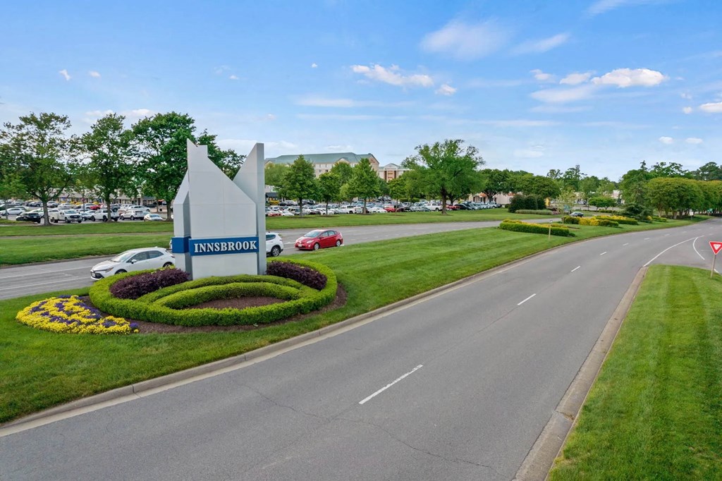 a street with a sign and flowers on the side of a road at Metropolis Apartments, Glen Allen Virginia