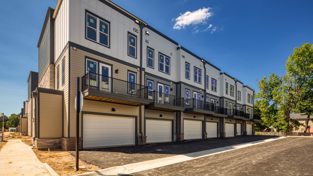a row of townhomes on a sunny day with trees in the background at Ainsworth, Richmond