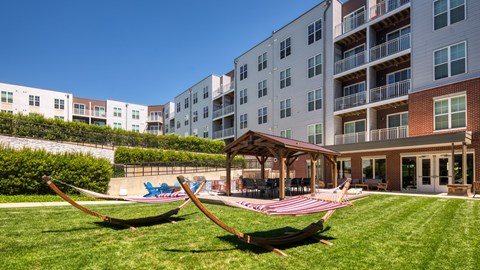 A playground with a swing set and a building in the background.